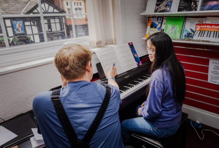 Booths Tutor Tom Giving a Piano Lesson