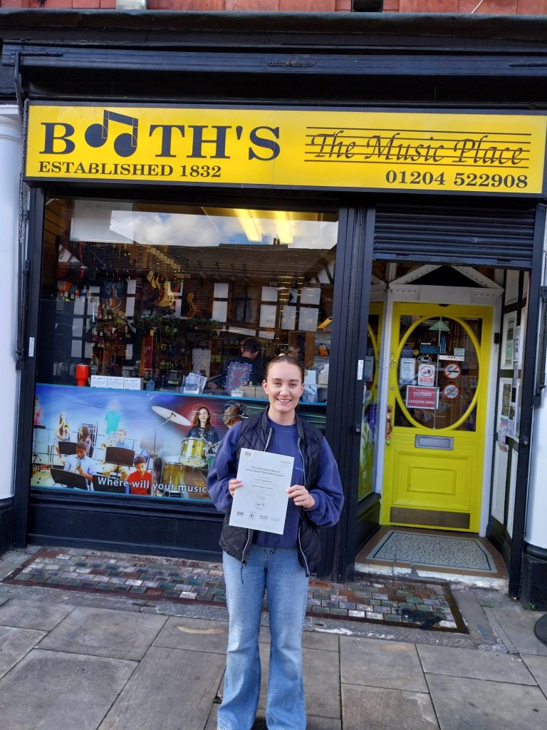 Alice with her Grade 5 Certificate outside Booths Music
