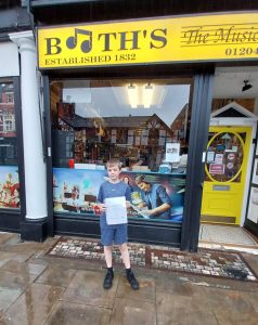 James holding piano certificate at Booths Music Bolton
